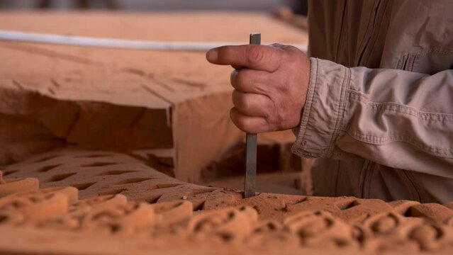 Armenian Khachkar art, Cross stone restauration․ Master's hands engraving the stone with instrument. Making Armenian cross stones: Khachqar. Khachkars are characteristic of Medieval Christian Armenian