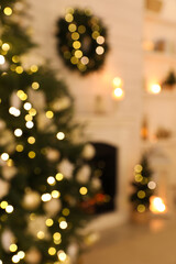 Blurred view of decorated Christmas tree and fireplace in room