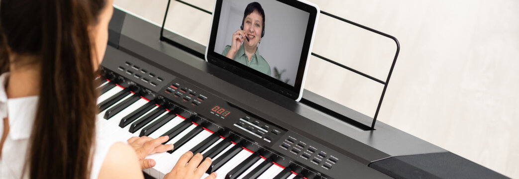 little girl play piano in class education with tablet in home online learning in covid-19 crisis quarantine