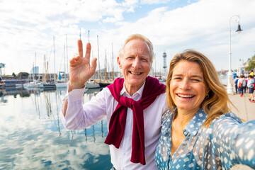 Happy senior couple taking a selfie at seaside in Barcelona