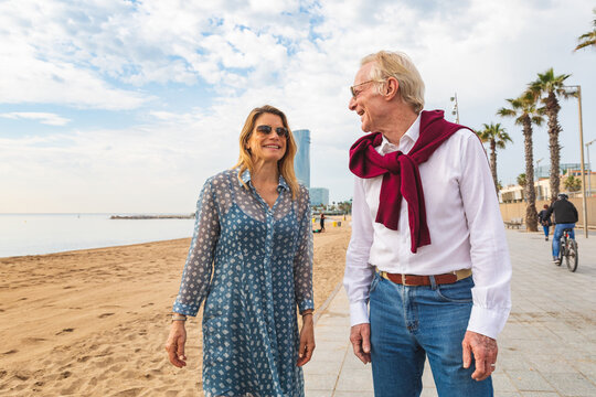 Senior couple walking on the beach in Barcelona
