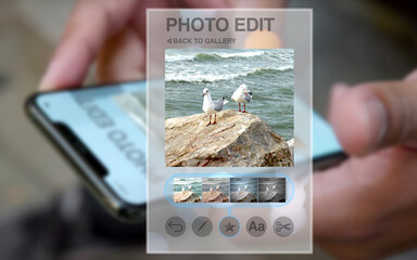 fictitious photo editing app on the smartphone shown as a hologram, in the background hands using a smartphone, enhancement and adjustments of images, cropping, color, brightness, filters, media