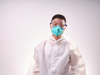 A health care worker wearing a mask and protective clothing on a solid color background