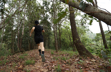 Woman runner running on forest trail