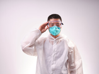 A health care worker wearing a mask and protective clothing on a solid color background