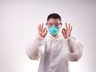 A health care worker wearing a mask and protective clothing on a solid color background