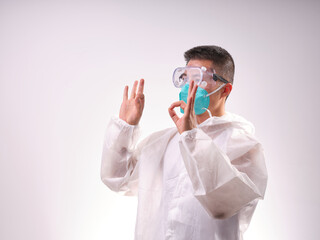 A health care worker wearing a mask and protective clothing on a solid color background