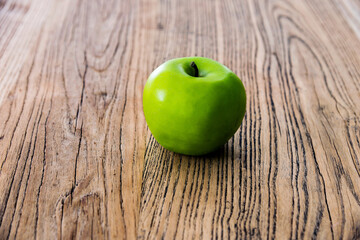 Green apple on old wooden table