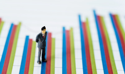 Miniature figure businessman standing on a graph chart