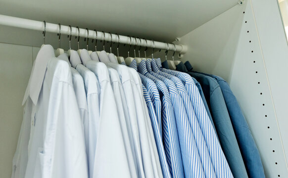 Row of cloth hangers with shirts