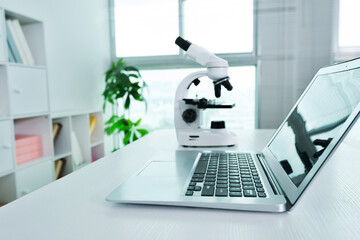 Laptop and microscope on a table