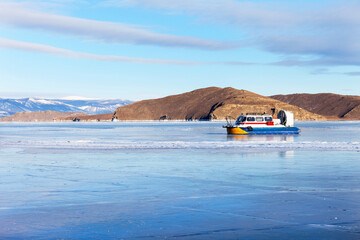 Frozen Baikal Lake. Hovercraft Hivus transports tourists through the Olkhon Gate Strait to Olkhon Island. Winter travel
