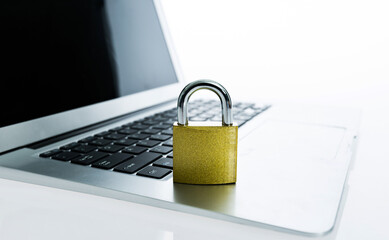 Single padlock on laptop keyboard against white background