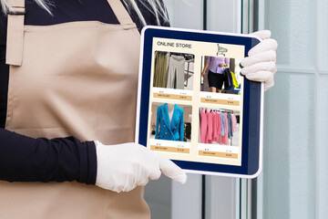 Woman shopping food online using a digital tablet at the kitchen, close-up view on a tablet screen. Concept of buying online using tablet.