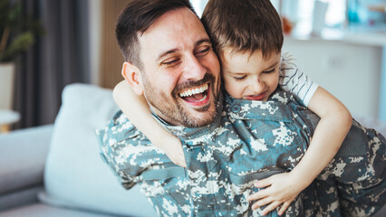 Smiling soldier reunited with his son after coming back from war. Soldier and his little son with...