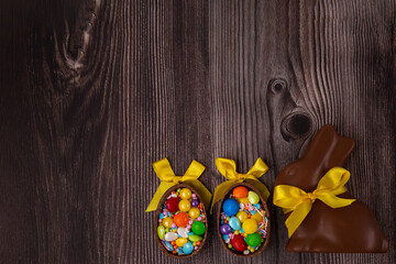 Fototapeta premium Chocolate Easter eggs over rustic wooden background. Copy space