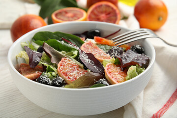Bowl of delicious sicilian orange salad on white wooden table, closeup