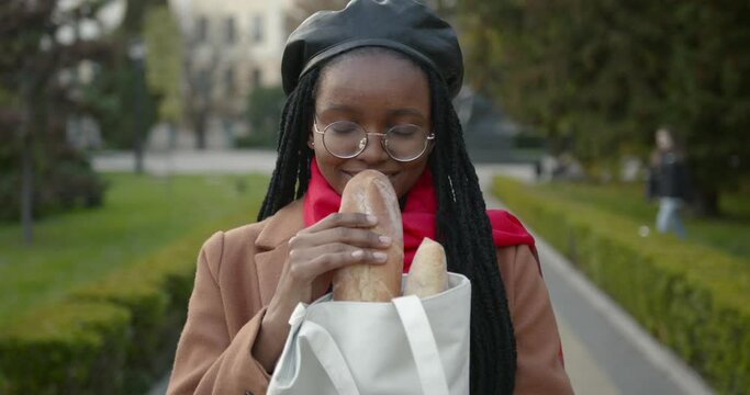Young black girl in a beret with a baguette in her hands