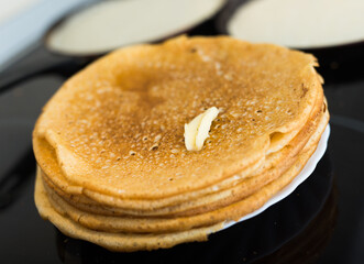 stack of appetizing flour pancakes in the kitchen during cooking