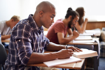Hes got great study habits. Cropped shot of a young college students in class.