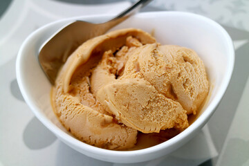 Closeup of mouthwatering homemade caramel ice cream in a white bowl