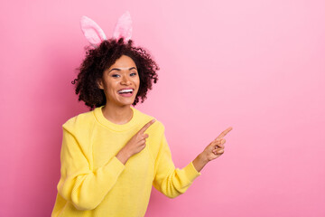 Photo of pretty adorable woman dressed kitted pullover easter headband pointing empty space isolated pink color background