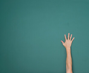 Raised hand in front of chalkboard