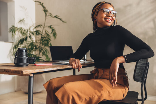 Happy graphic designer contemplating new ideas in her office - Powered by Adobe