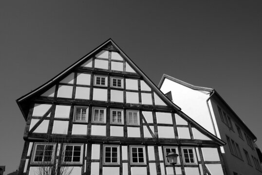Sch&ouml;nes altes Fachwerkhaus mit langem geschwungenen Giebel bei Sonnenschein in der Altstadt von Blomberg in Ostwestfalen-Lippe, fotografiert in klassischem Schwarzwei&szlig;