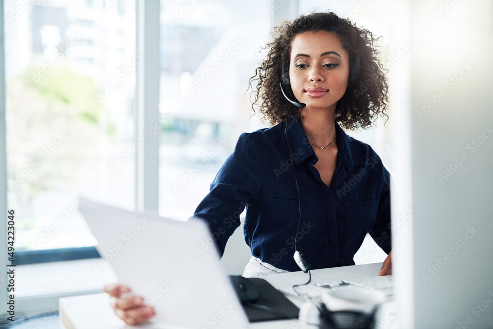 Poster reading over her reports. cropped shot of an attractive young female call center agent reading some 