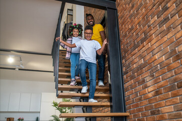 Boy girl and man going down stairs at home