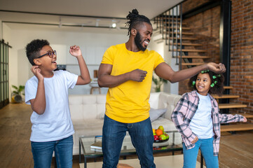 Man showing muscular arm to enthusiastic kids