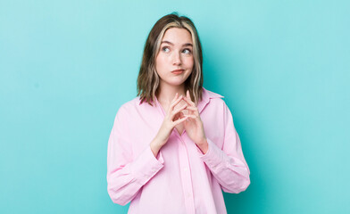 pretty caucasian woman feeling proud, mischievous and arrogant while scheming an evil plan or...