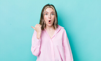 pretty caucasian woman looking astonished in disbelief, pointing at object on the side and saying...