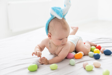 Portrait of a cute baby dressed in Easter bunny ears with a basket full of eggs