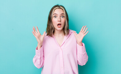 pretty caucasian woman looking shocked and astonished, with jaw dropped in surprise when realizing...