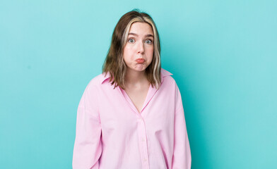 pretty caucasian woman with a goofy, crazy, surprised expression, puffing cheeks, feeling stuffed,...