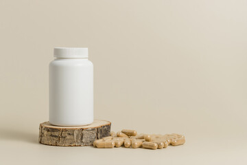 Mockup bottle on wooden stand with natural bio pills or vitamins, beige background. White bottle...