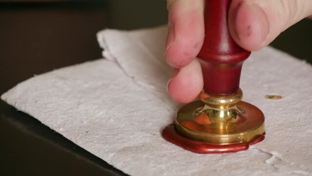 Creating a wax seal on a parchment.
