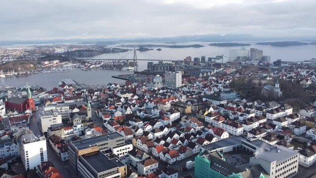 Flying over Stavanger urban city centre and towards the city bridge - Vassoy ferry passing under bridge - Norway Aerial