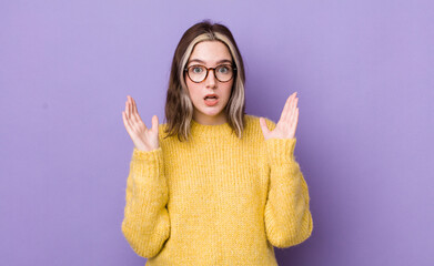 pretty caucasian woman looking shocked and astonished, with jaw dropped in surprise when realizing...
