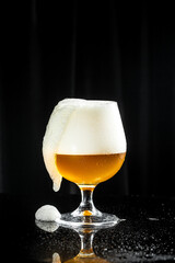 Beer. Cold Craft light Beer in a glass with water drops. Pint of Beer into a tall glass with a thick foam