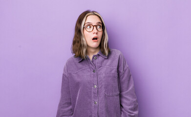 pretty caucasian woman feeling shocked, happy, amazed and surprised, looking to the side with open...