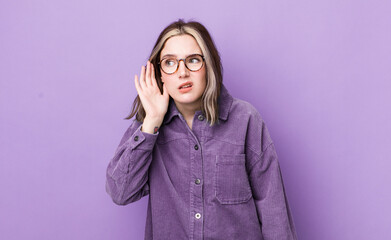 pretty caucasian woman looking serious and curious, listening, trying to hear a secret conversation...