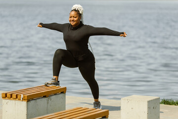Afro-american plus size woman doing yoga outdoor
