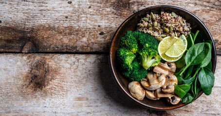 Diet salad made from fresh vegetables broccoli, mushrooms, spinach and quinoa in a bowl. Delicious breakfast or snack, Clean eating, dieting, vegan food concept. Long banner format. top view