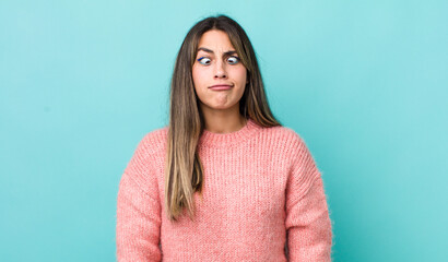 pretty hispanic woman looking goofy and funny with a silly cross-eyed expression, joking and fooling around - obrazy, fototapety, plakaty