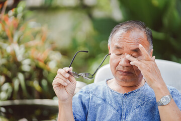 An elderly man rubbing his eyes due to excessive use of his eyes, causing itching and irritation.