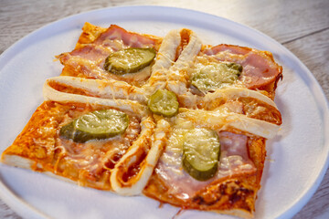 pizza square with ham cheese and pickled cucumber