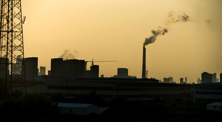 Factory pipe polluting air at dusk